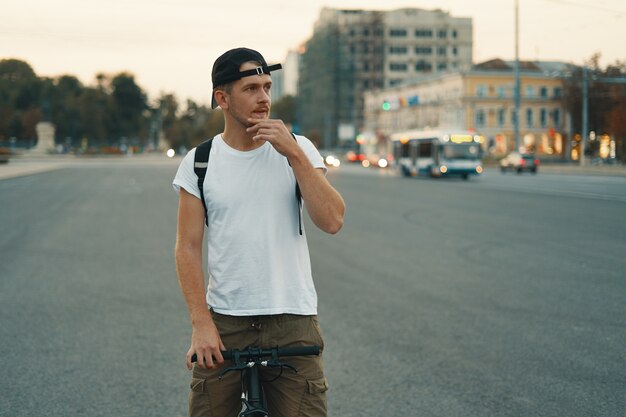 Man riding bicycle in urban city holding hand on handlebar