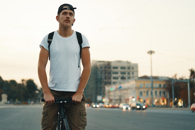 Человек езда на велосипеде в городском городе, держась за руки на руле, затуманенное город