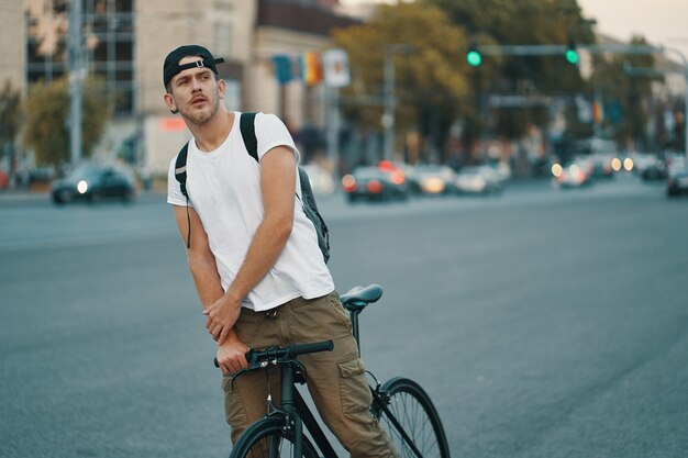 Man riding bicycle in urban city holding hands on handlebar