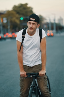 Free Photo | Man riding bicycle in urban city holding hands on handlebar