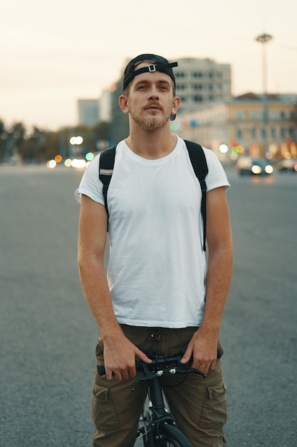 Man riding bicycle in urban city holding hands on handlebar