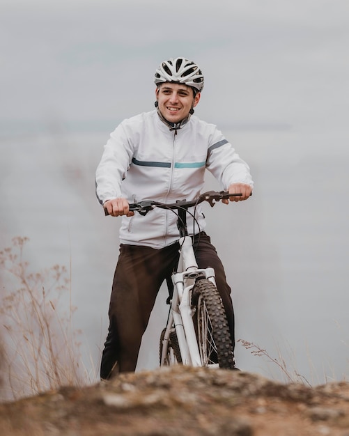 Free photo man riding a bike on a cold day