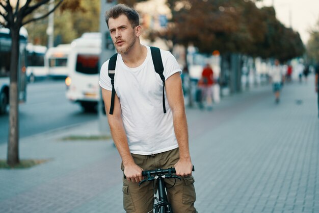 古いヨーロッパの都市の屋外で自転車に乗る男