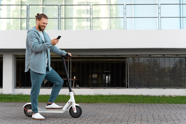 Foto gratuita uomo che guida uno scooter ecologico eco