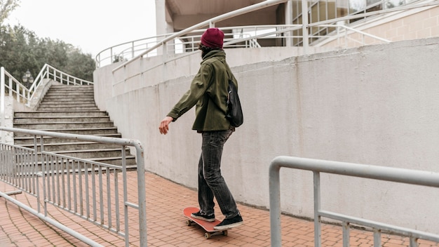 도시에서 밖에 서 그의 스케이트 보드를 타는 남자