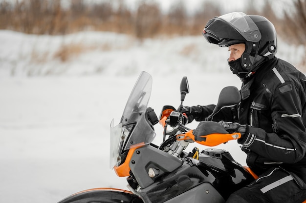 Foto gratuita uomo in sella a moto il giorno d'inverno