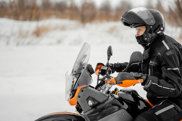 Man riding motorcycle on winter day