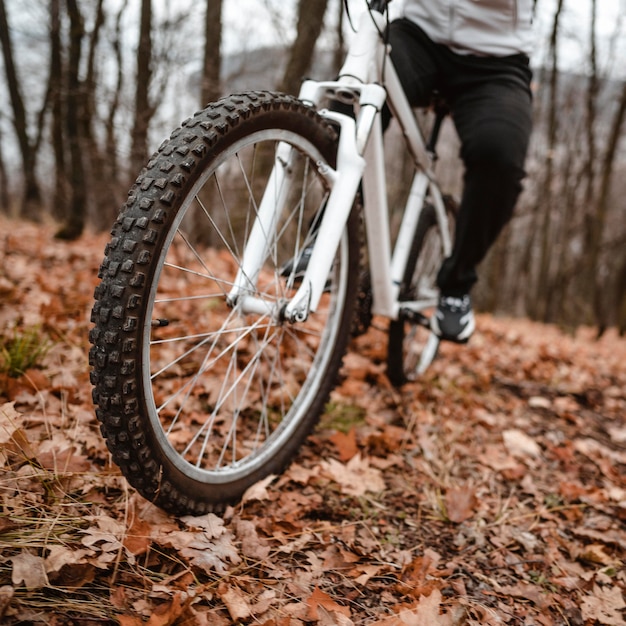 Free photo man riding a mountain bike on autumn leaves