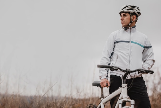 Free photo man riding a mountain bike in special equipment with copy space