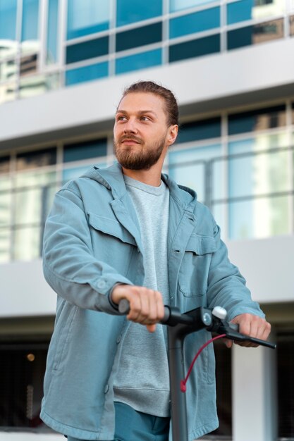 Free photo man riding a scooter outdoors