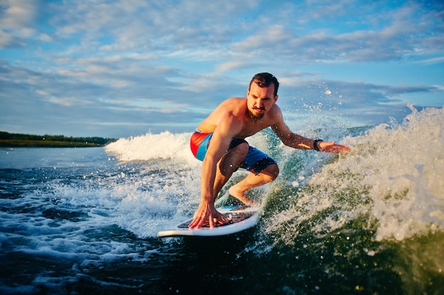 Man riding wave at sunrise