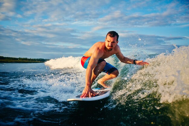 Man riding wave at sunrise