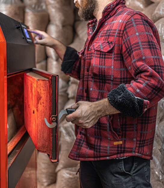 a man in a room with a solid fuel boiler, working on biofuel, economical heating.