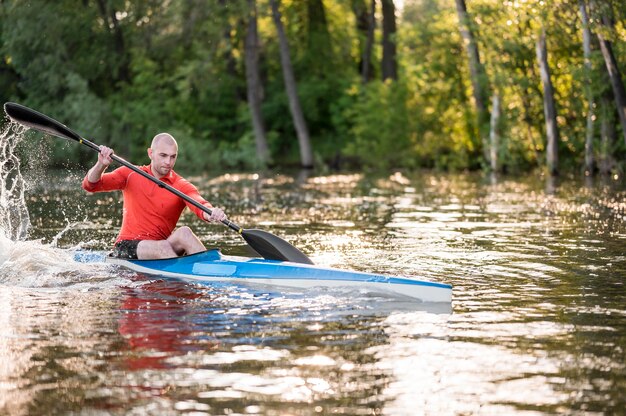 Man rowing in blue canoe