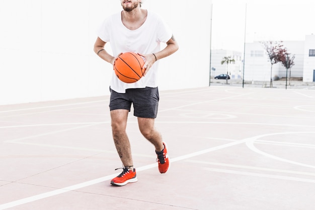 バスケットボールで走っている男