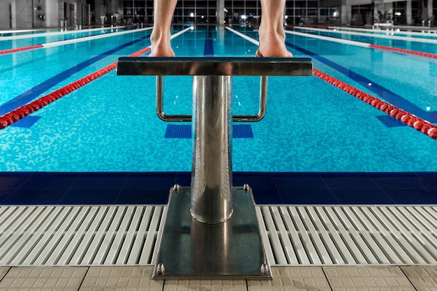 Man's feet standing on the starting blocks