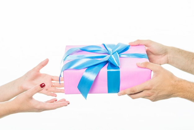 Man's hand giving gift to his girlfriend over white background