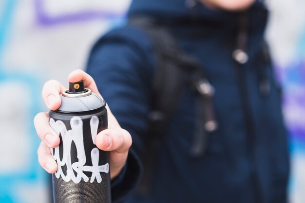 Man's hand holding aerosol can