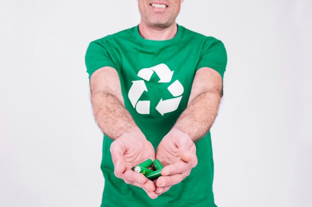 Рука человека с зелеными батареями