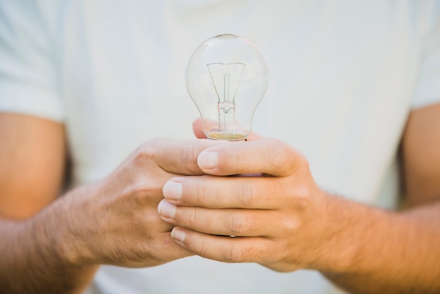 Man's hand holding light bulb