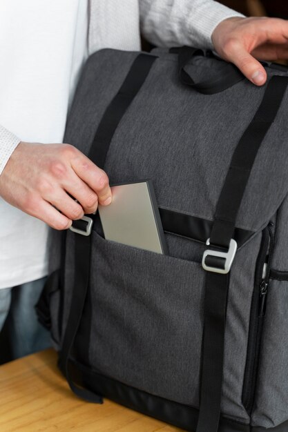 Man's hand putting ssd in backpack