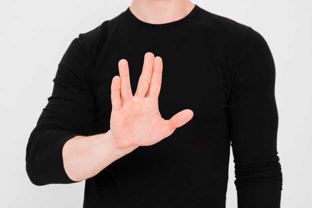 Man's hand showing stop gesture against white backdrop