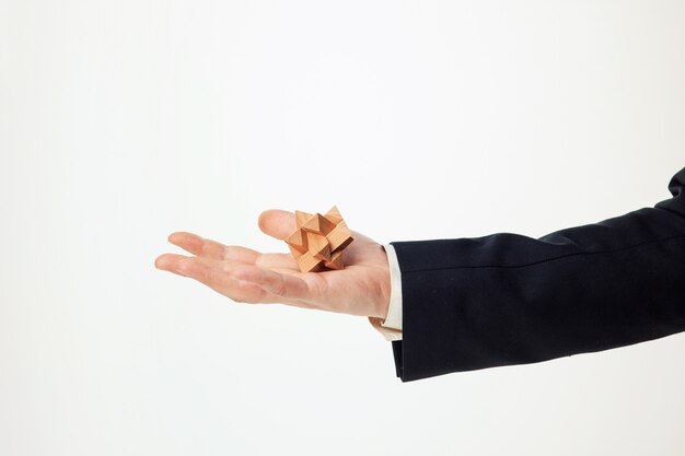 Man's hands holding wooden puzzle.