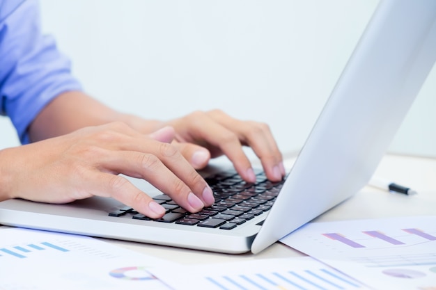 Man's hands typing on laptop keyboard.