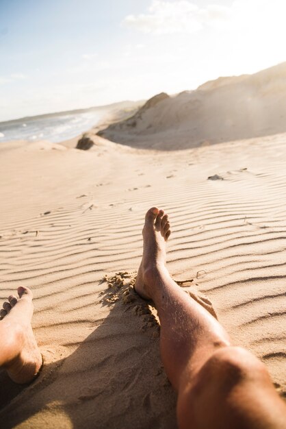 Man's legs in the sand close up