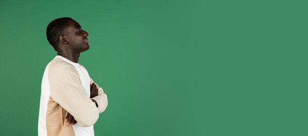 Man's portrait isolated on green studio wall