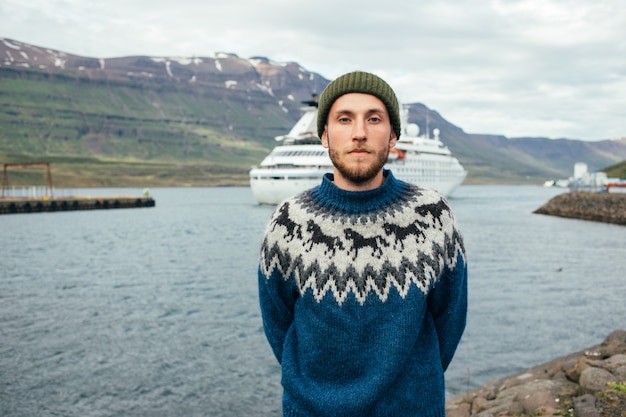 Man sailor in traditional sweater stand in fjord port