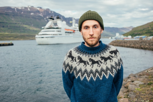 Free photo man sailor in traditional sweater stand in fjord port