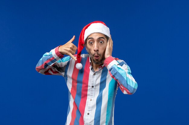 Man in santa hat doing phone hand gesture