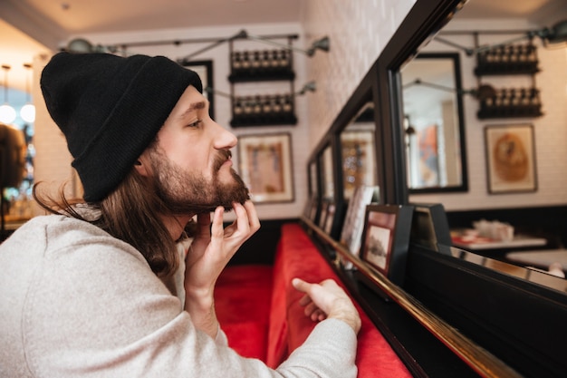 Foto gratuita uomo che si gratta la barba vicino allo specchio