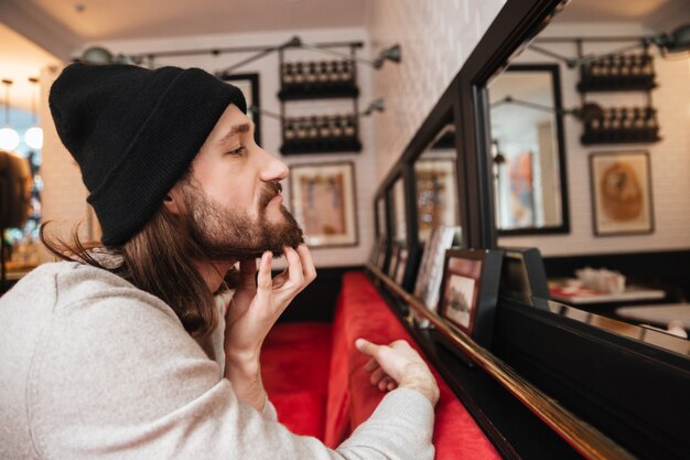 Man scratching his beard near the mirror