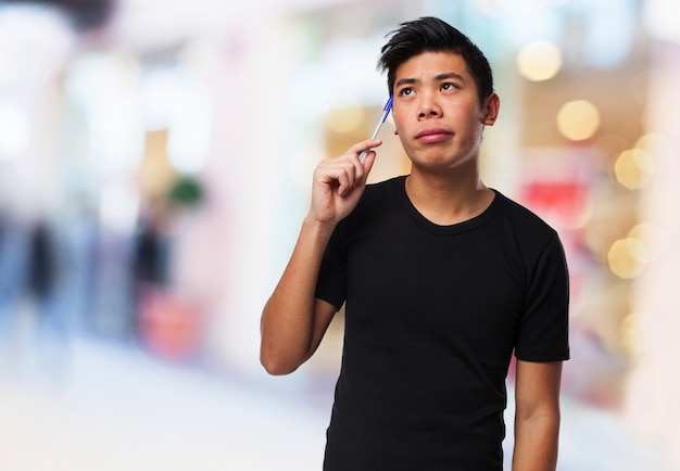 Man scratching his temple with a pen