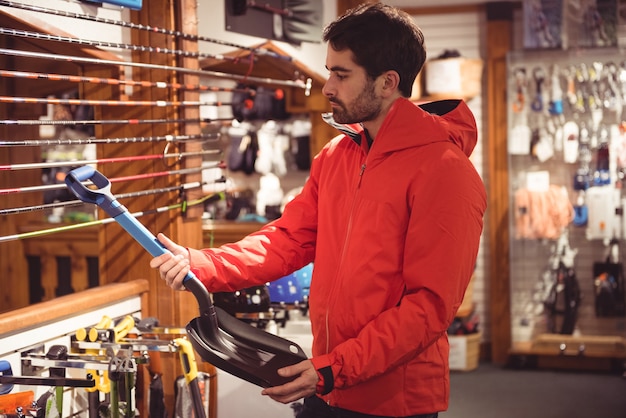 Man selecting shovel in a shop