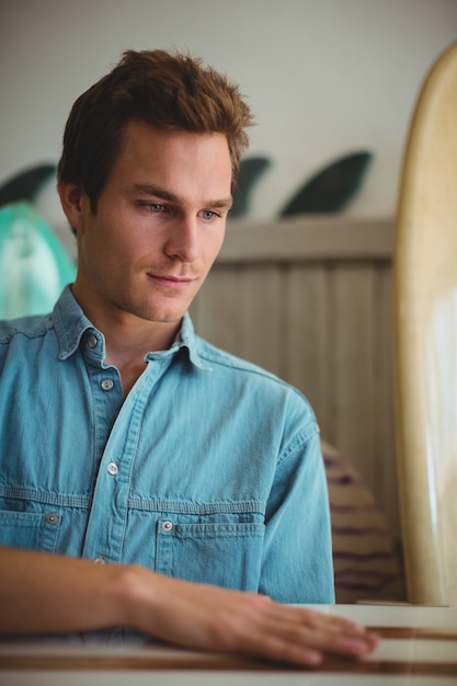 Free photo man selecting surfboard