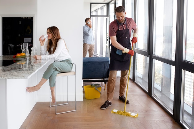 Foto gratuita servo uomo che pulisce la casa