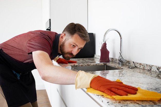 Foto gratuita servo uomo che pulisce la cucina