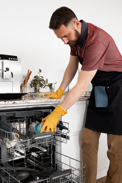 Free photo man servant cleaning the kitchen