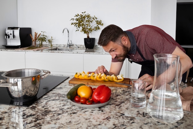 Foto gratuita servo uomo che cucina in cucina