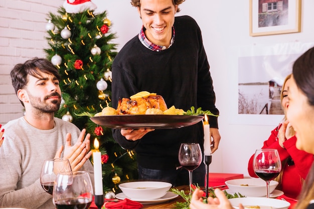 Man serving christmas dinner with turkey