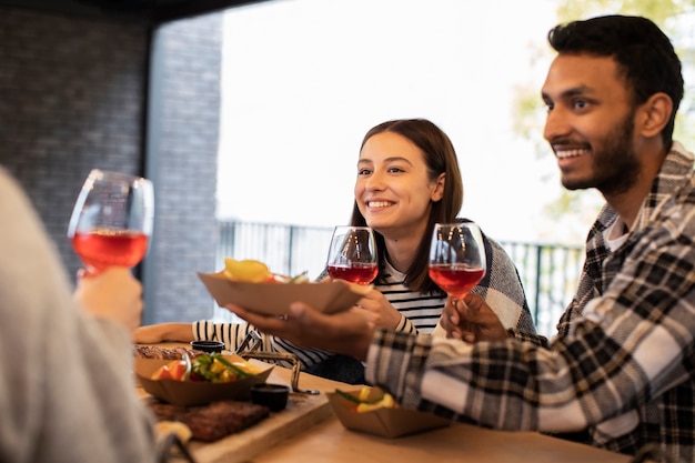 無料写真 テーブルで友達に食べ物を提供し、飲み物を持っている男