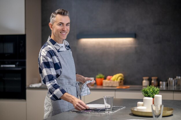 Man serving table at home looking at camera