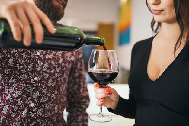 Man serving wine for woman having date