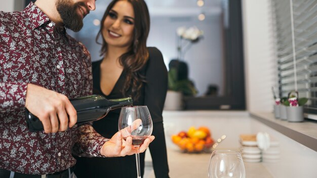 Man serving wine for woman