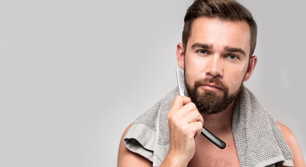 Man shaving his beard with copy space