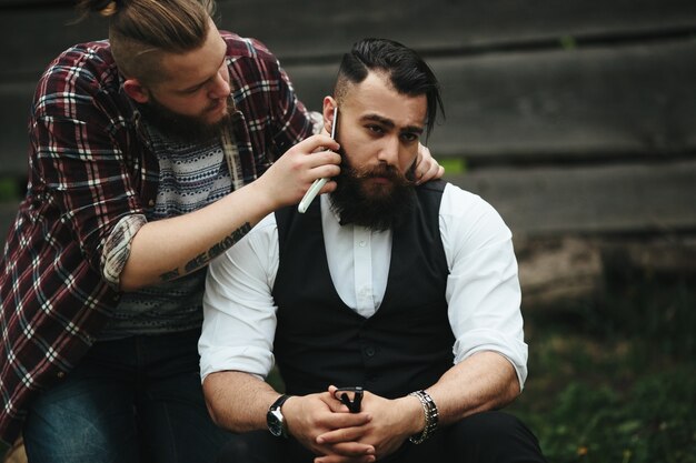 Man shaving his friend