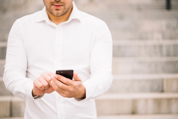 Free photo man in shirt using smartphone